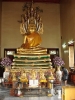 Buda en monasterio budista. Los fieles lo veneran pegando decoraciones de papel